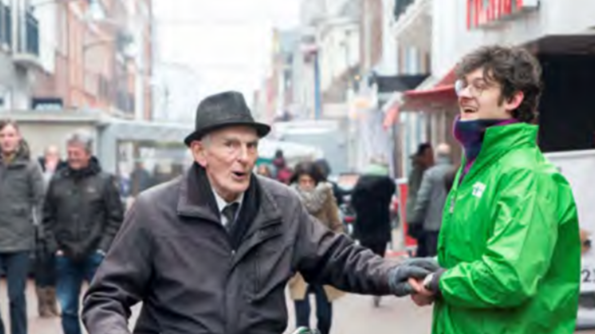 Foto van een GroenLinks-vrijwilliger en een man op een driewieler